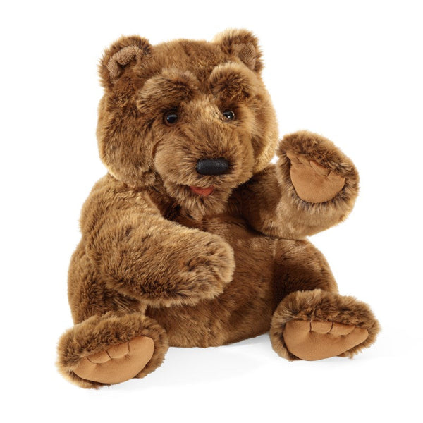 A brown plush teddy bear hand puppet sitting upright with one paw raised in a waving gesture.