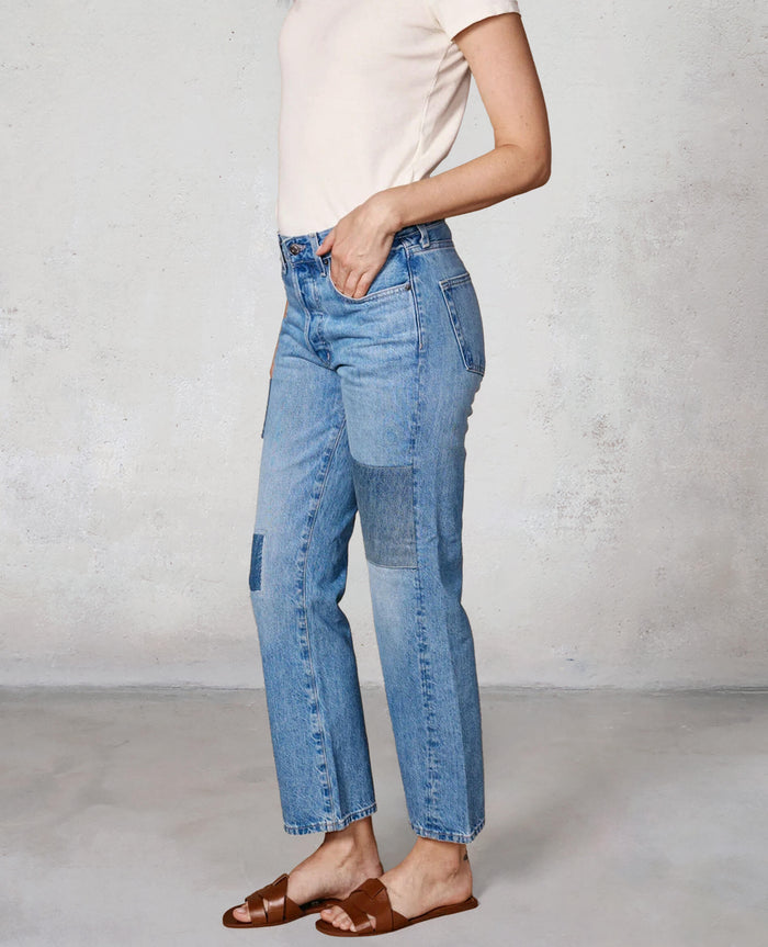 Person wearing light blue jeans with a white background