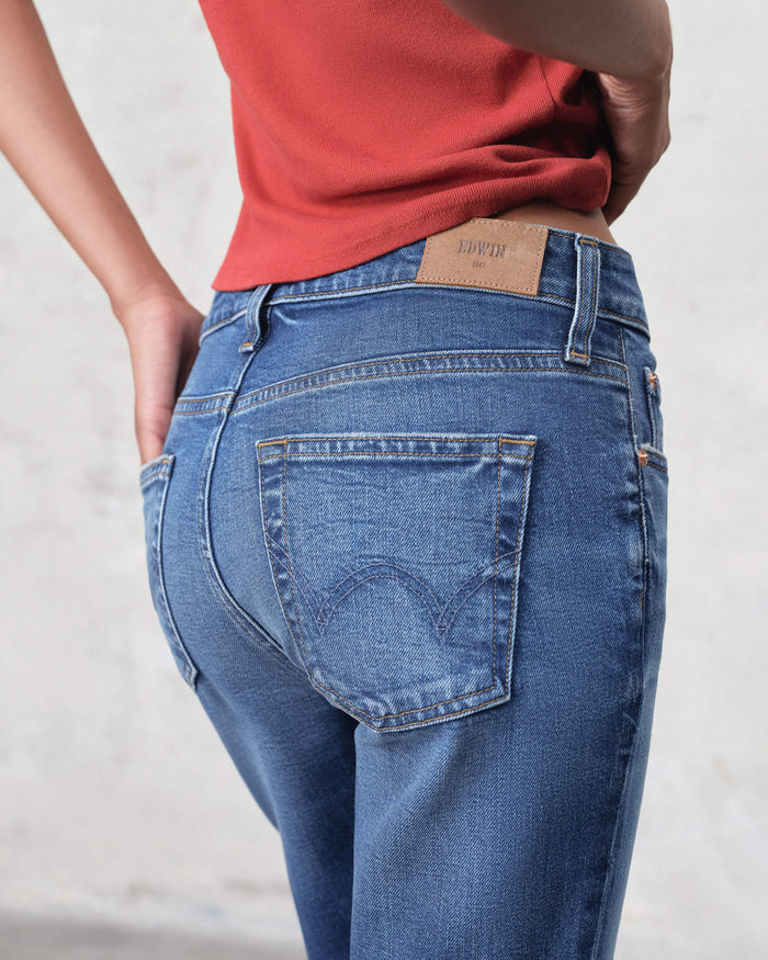 EDWIN USA premium ankle bootcut denim blue jeans back view with leather patch high rise fit and red top