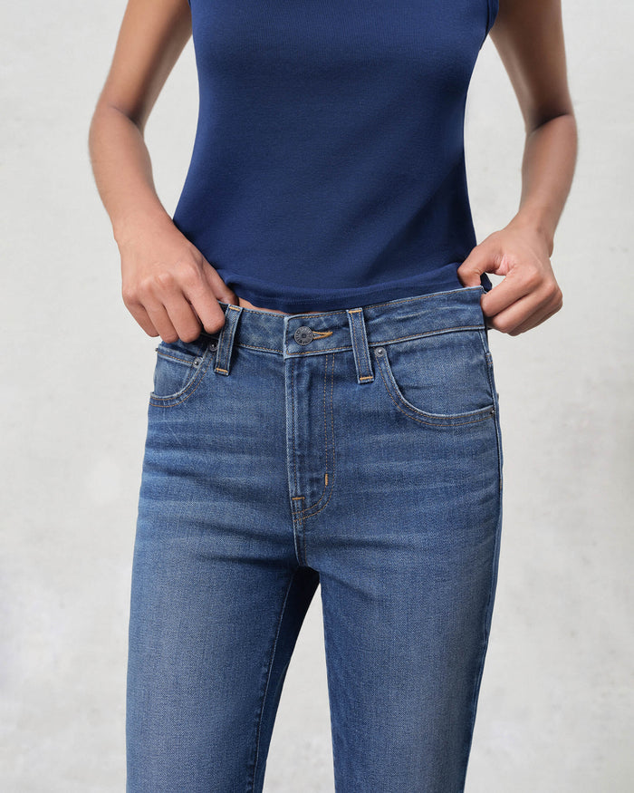 EDWIN premium bootcut denim jeans on model wearing navy tank midrise waist and classic blue wash