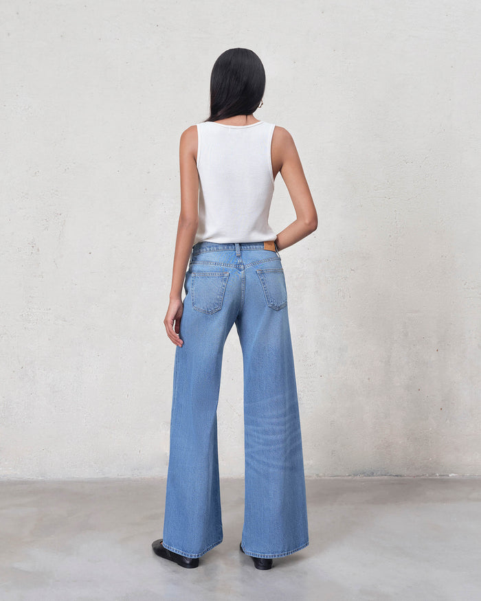 EDWIN light blue denim super wide leg jeans women back view on model with white tank top