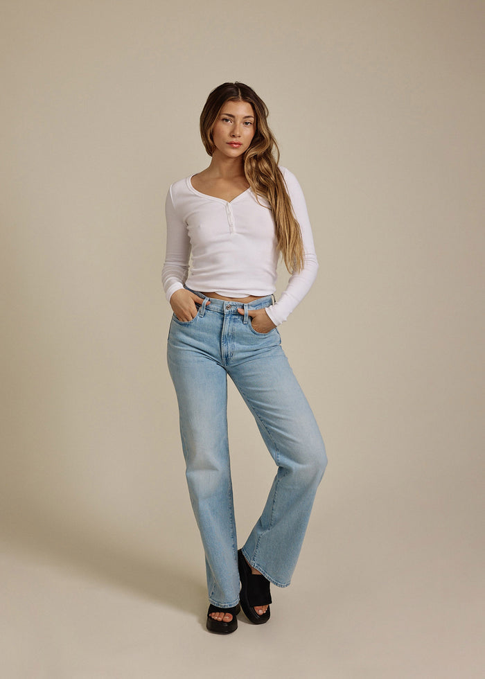 Woman wearing EDWIN USA light blue high rise wide leg jeans for women with white long sleeve top
