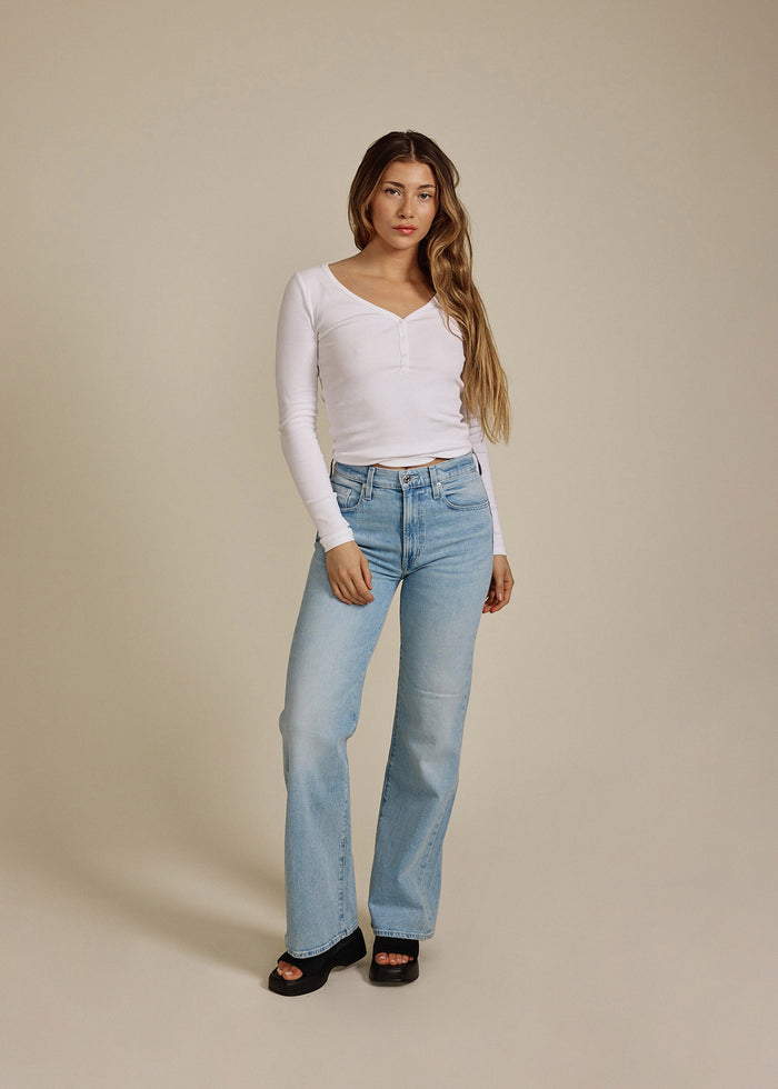 Woman wearing EDWIN USA high rise wide leg jeans for women in light blue denim with black sandals