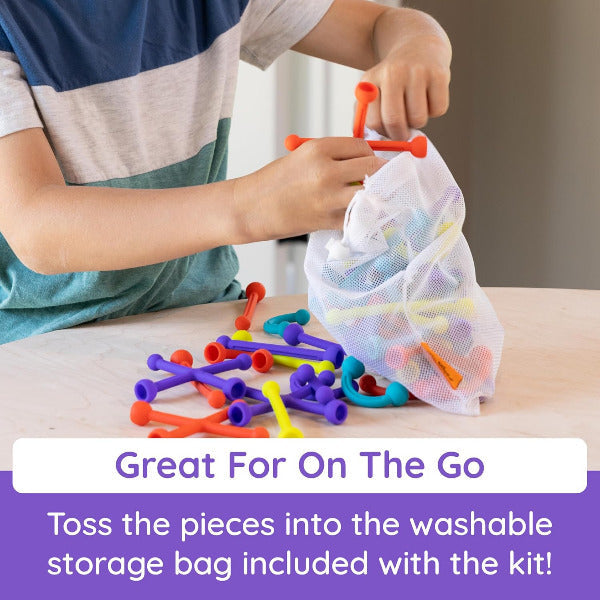 Child playing with colorful interlocking toys and a washable storage bag on a table.