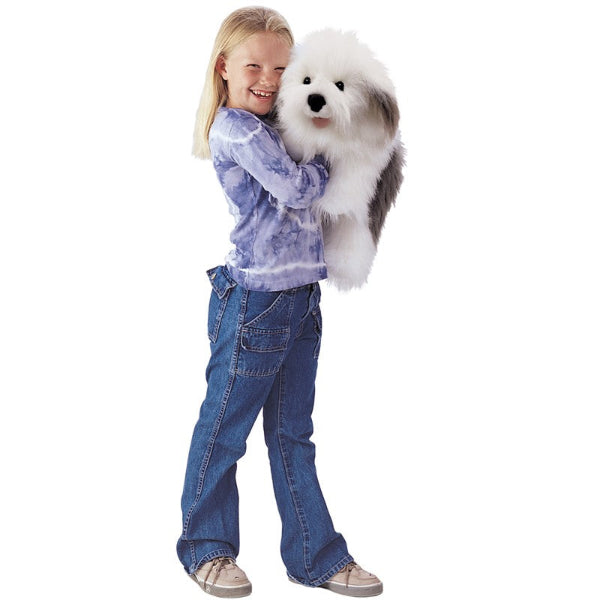 Child holding a fluffy white sheepdog puppet