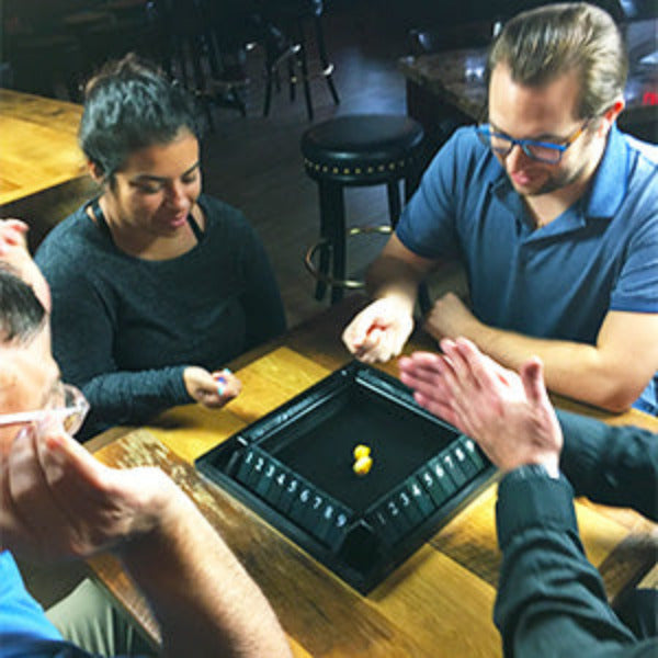 People playing a board game together at a table in a casual setting