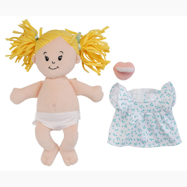 Plush doll with yellow hair and diaper next to a floral dress