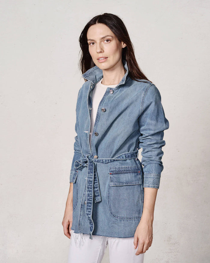 Woman wearing a denim jacket on a plain background