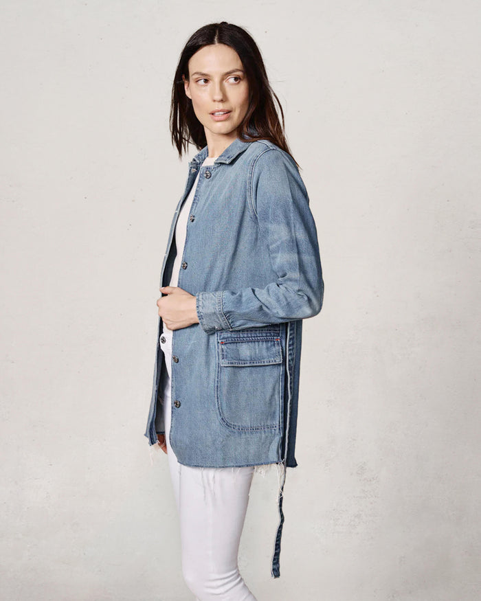 Woman wearing a denim jacket on a plain background