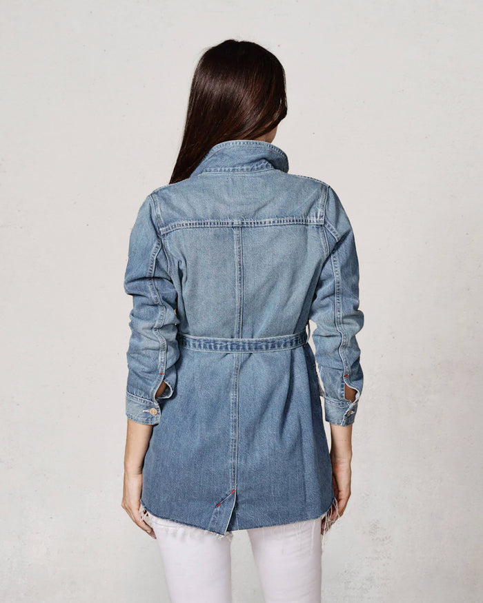 Woman wearing a denim jacket on a plain background