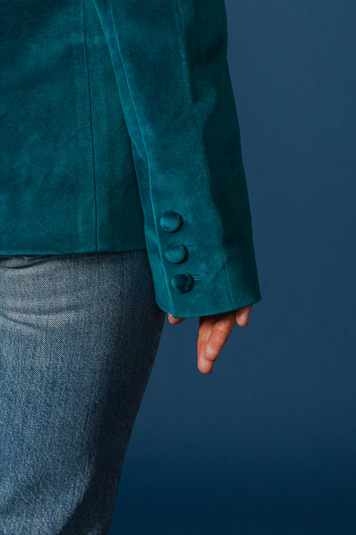 Close-up of the sleeve and buttons on the deep lagoon velvet jacket by EDWIN USA worn with jeans